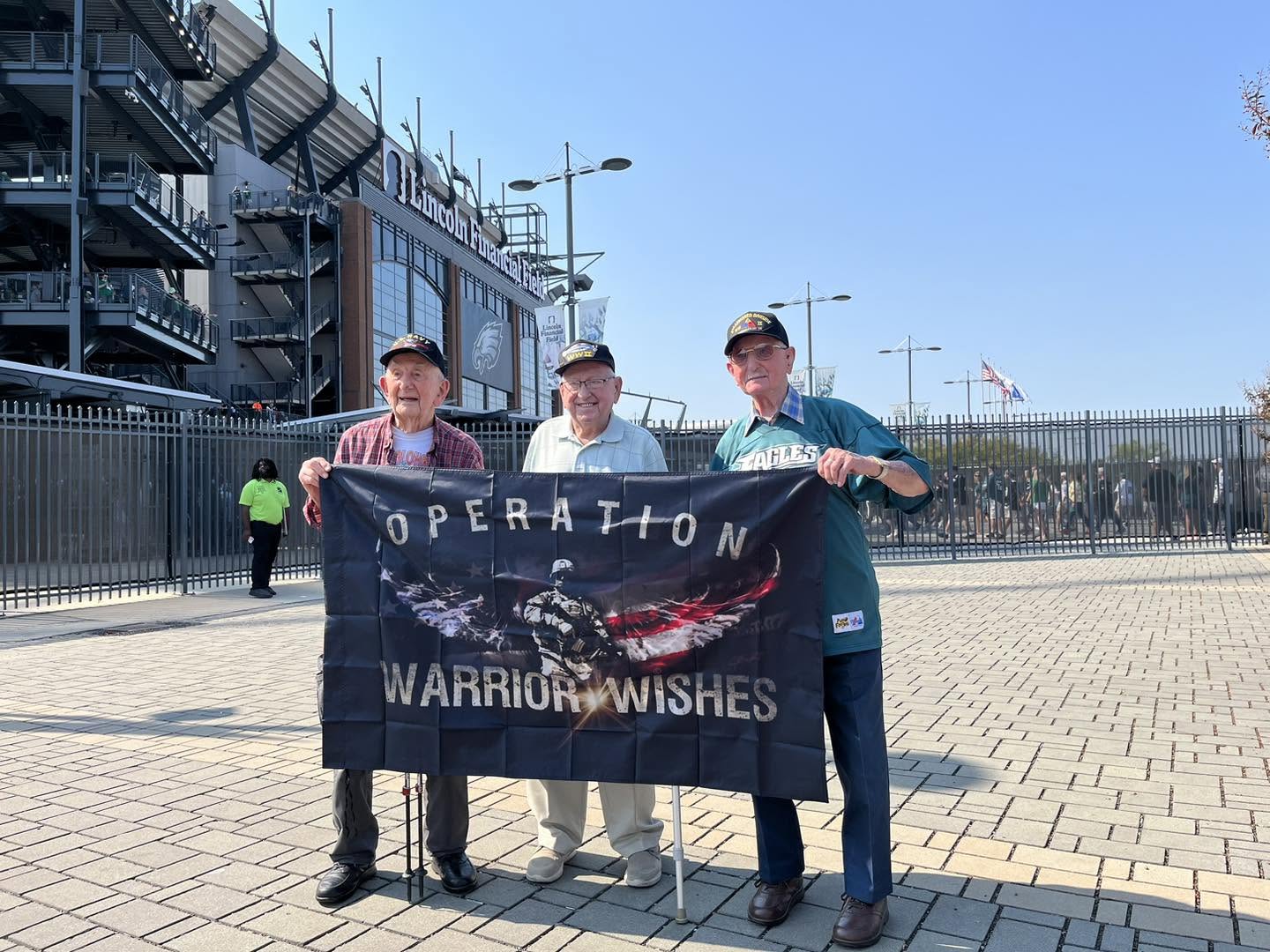 WWII veterans holding the Operation Warrior Wishes flag outside Lincoln Financial Field